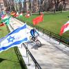 Person on bicycle riding through rows of international flags for Conference on World Affairs