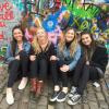 Four students sitting against wall in Prague