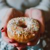 Person holding donut with sprinkles
