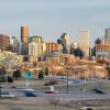 Denver's skyline. The foreground shows cars driving on a highway. 