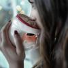 Person drinking hot chocolate out of a Santa mug