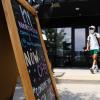 A man leaves a Denver business wearing a mask.