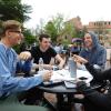 students sitting at a table outside on campus