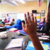 student raises hand in classroom