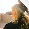 person in graduation cap and gown on rooftop alone