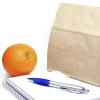 Brown-bag lunch, notebook, pen and an orange