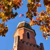 Old Main building framed by autumn leaves