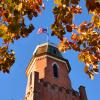 Old Main building framed by autumn leaves