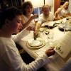Person reading from the Haggadah while preparing to dip parsley into salt water