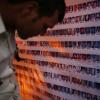 a wall of photos of missing people in Nepal