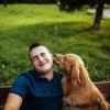 person and dog sit on park bench