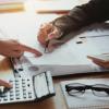 People handle what appear to discuss financial documents.