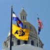 A CU, Colorado and United States flag at the Denver capitol building.
