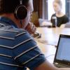 Graduate student working on computer with headphones
