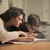 Adult helping young student with homework
