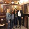 Three female college students pose with owner of carpet shop in Istanbul, Turkey
