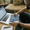 person working on tablet and laptop