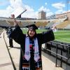 Valeria Ayala Alonso celebrates after getting her photo taken at Folsom Field during Grad Appreciation Days events