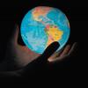 Two hands hold a globe, lit from inside. (Photo by Greg Rosenke/Unsplash)