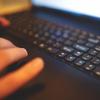 A hand typing on a laptop keyboard