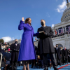 Outside the U.S. Capitol Building, Kamala Harris places her hand on a Bible held by a man