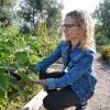 Professor Jill Litt looks over an eggplant at a community garden next to Regis University in Denver