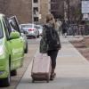 Student leaving campus with suitcase