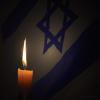 Candle burns with Jewish star in background