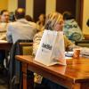 Employees with swag bags sitting at tables during a wellness event