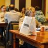 Employees with swag bags sitting at tables during a wellness event
