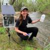 researcher collecting water from a stream