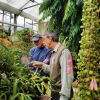 Tom Lemieux speaks with a man inside CU Boulder's EBIO greenhouse.