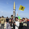 Students standing near a research rocket that they built.