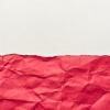 Red wrinkled paper against a white background