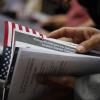 A newly naturalized U.S. citizen holding documents