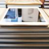 A modern digital tablet sits atop stacks of books. 