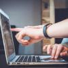Employees look at laptop screen