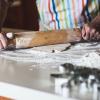 person rolling dough with rolling pin
