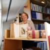 Kate Tallman sits at a table with a book open to a hand drawn owl.