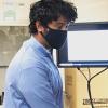 Assistant Professor Kaushik Jayaram works in the lab while wearing a mask