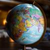 A globe on a wooden desk (Kyle Glenn/Unsplash)