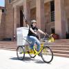 Woman on library bike in front of Norlin Library