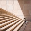 Small child stand at bottom of huge, stone stairs