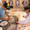 Artists work on part of a mosaic to commemorate 'Los Seis'