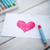 Red heart drawn on paper with oil pastel