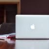 MacBook on table with book and iPhone