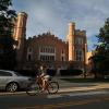 Students ride bikes past Macky Auditorium