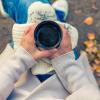 person holding cup of coffee while sitting outside in fall weather