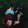 Two people lying in grass together