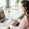 A person wearing a mask having a meeting online